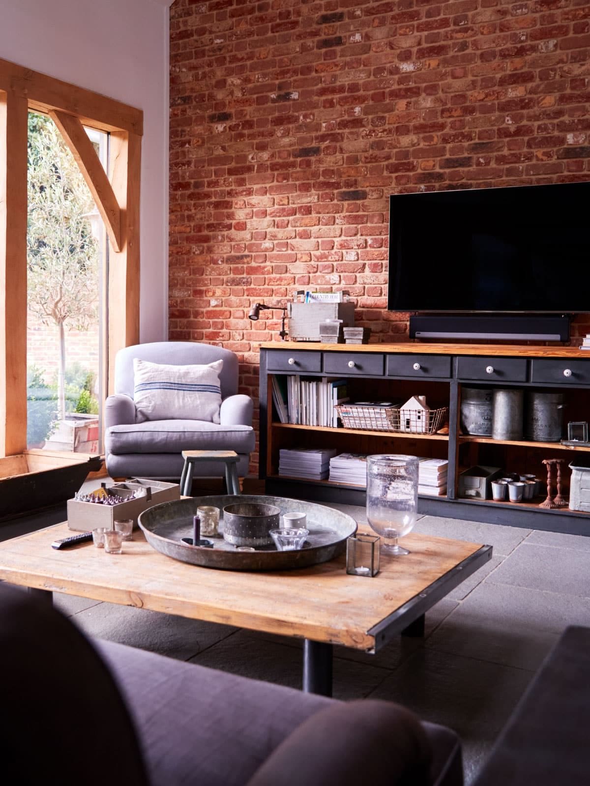 Refurbished living room with exposed beams and arched windows